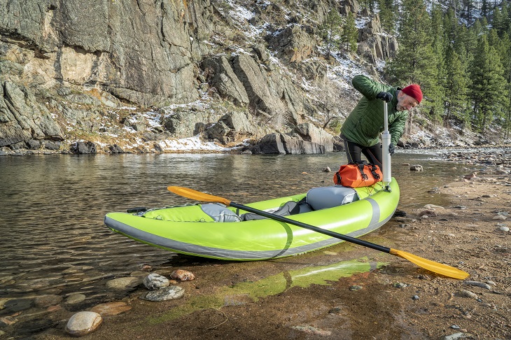 paddler pumping up  inflatable whitewater kayak