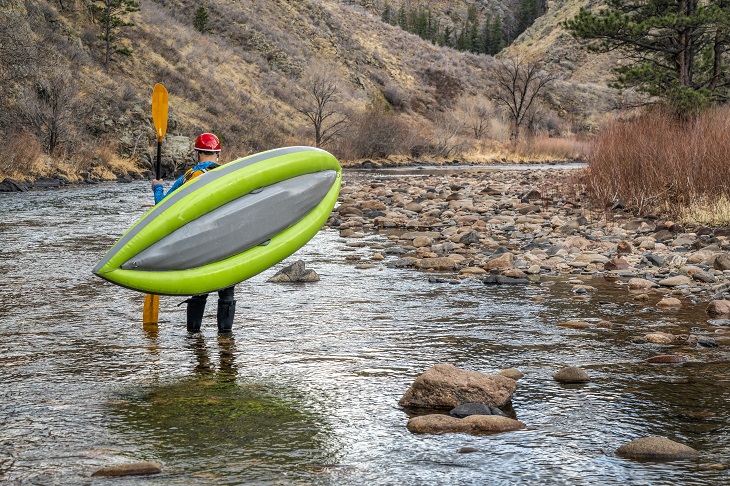 paddler carrying  inflatable kayak