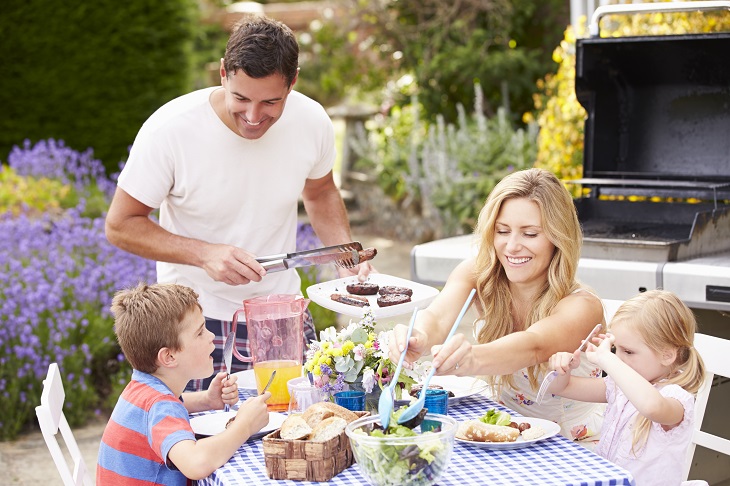 propane vs natural gas grills - Family Enjoying Outdoor Meal by grill
